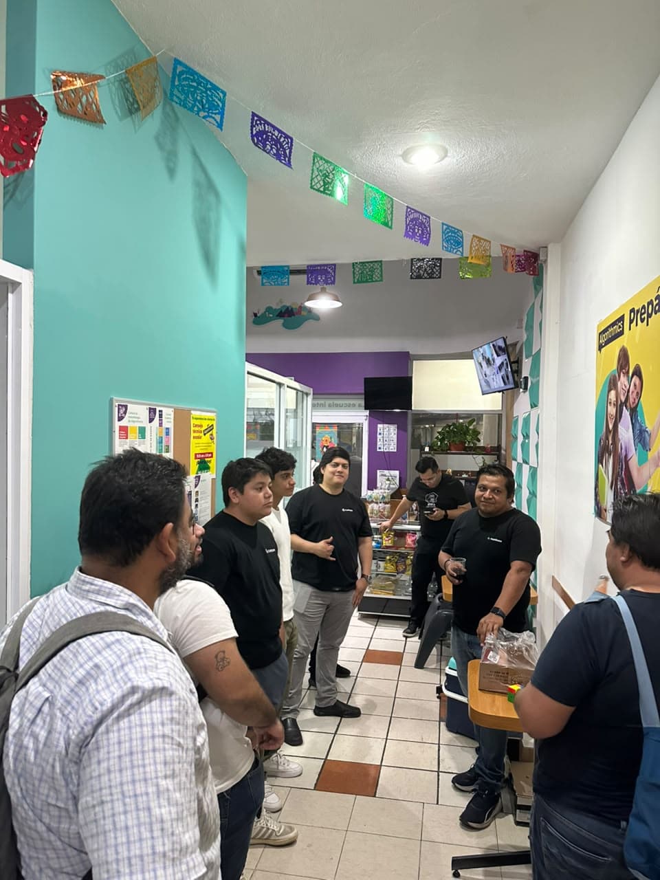 Pasillo con papel picado y personas de pie